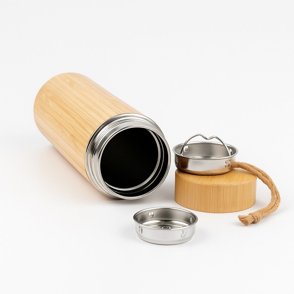Bamboo and stainless steel travel mug with accessories on a white background