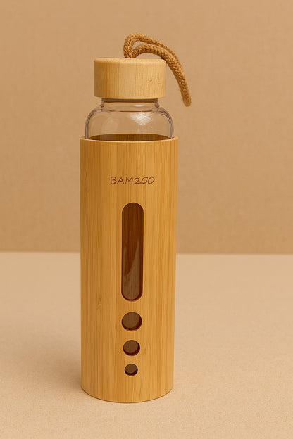 Bamboo water bottle with glass body on a beige background